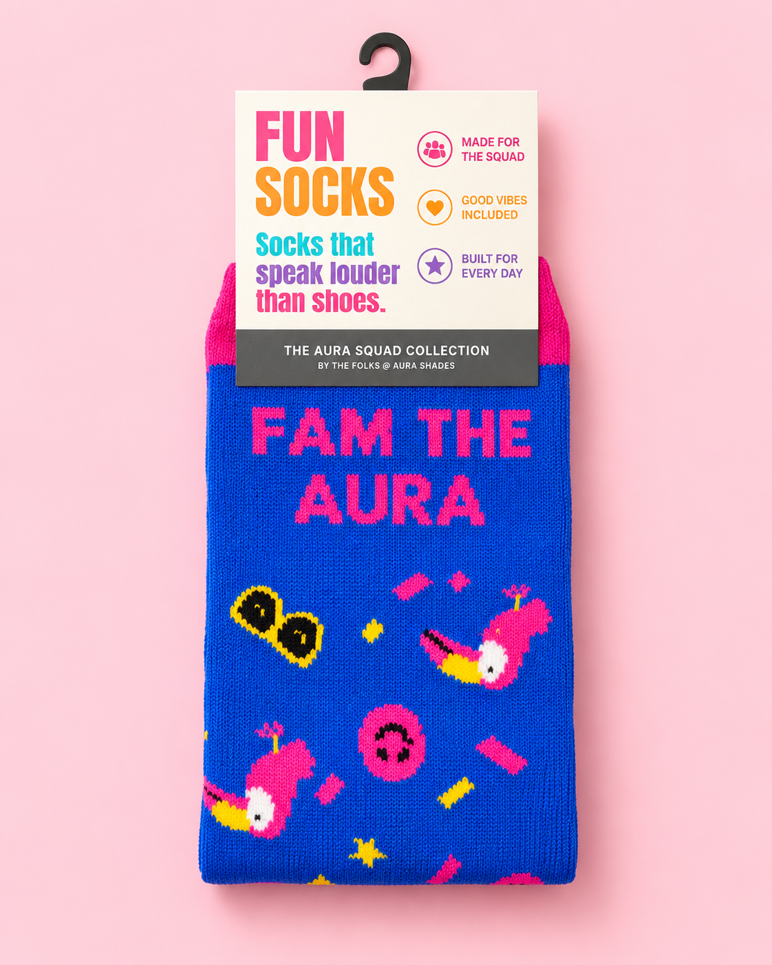 FAM the Aura crew socks by Aura Shades in royal blue with a pink cuff, featuring toucan, sunglasses, smiley face and confetti graphics, in The Aura Squad Collection packaging