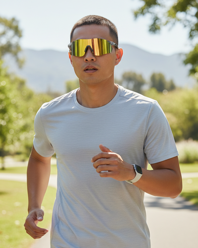 Man running outdoors wearing reflective sunglasses in carbon fiber frame and a white t-shirt.